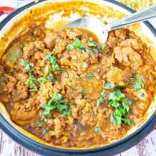 A skillet with chicken and lentil curry.