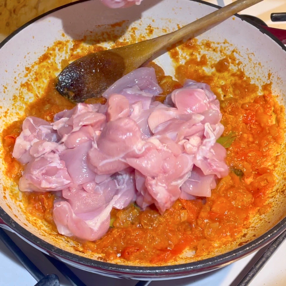Adding chicken with lentils for curry.