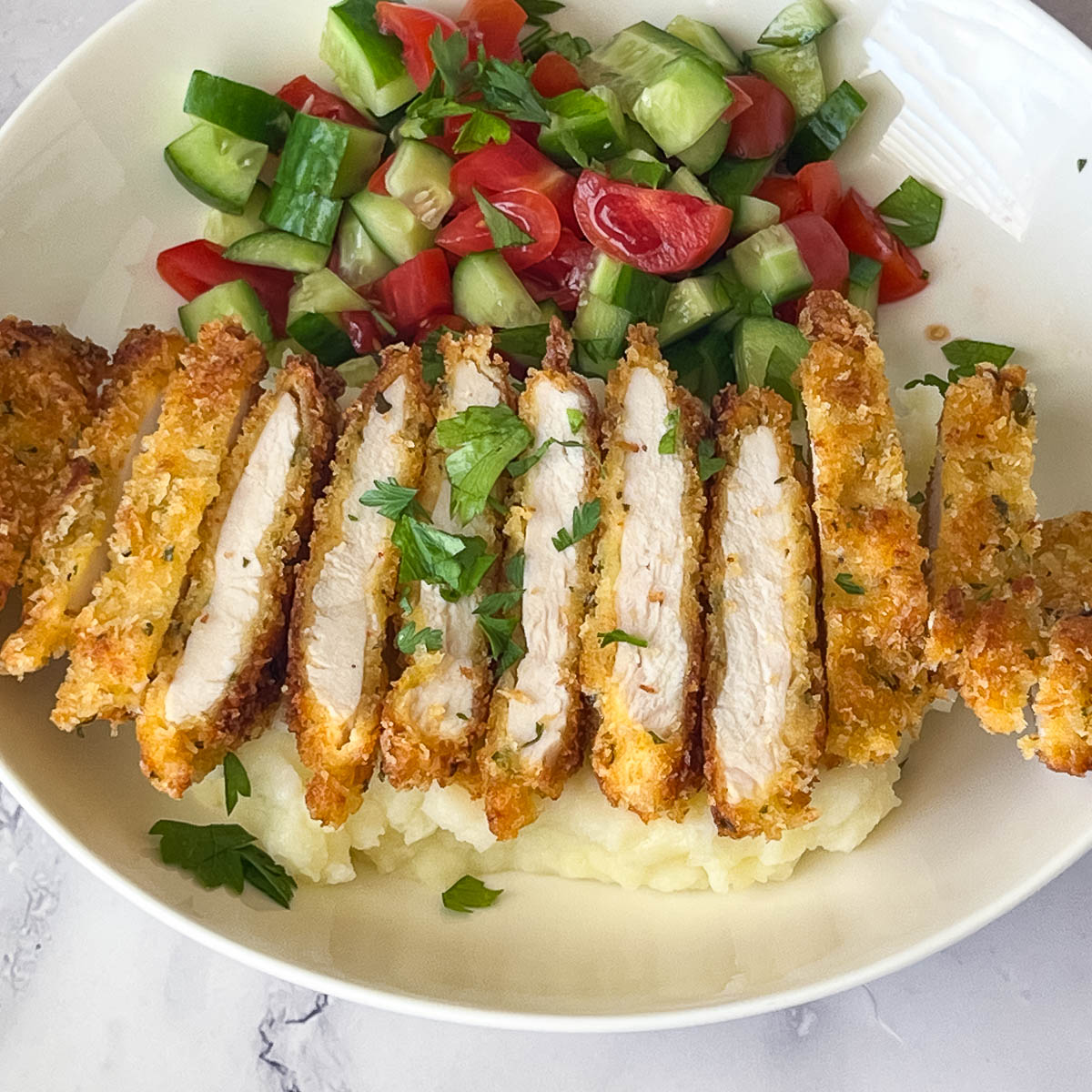 A sliced parmesan crusted chicken on a plate.