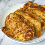 Parmesan crusted chicken on a white plate.