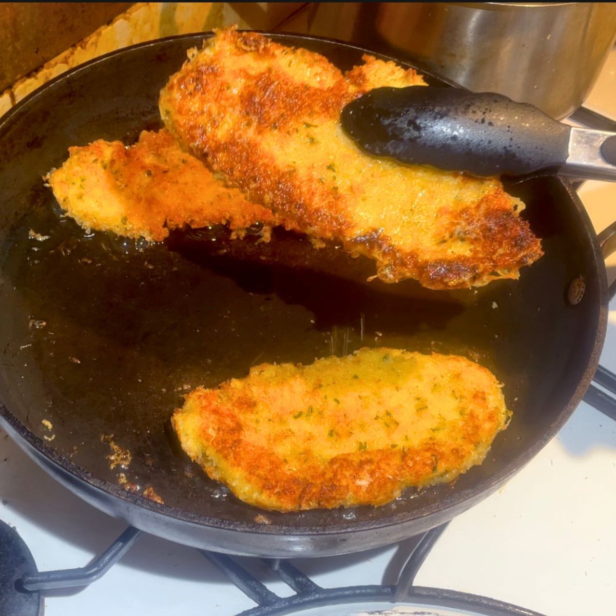 Drain chicken cutlets from the frying pan.