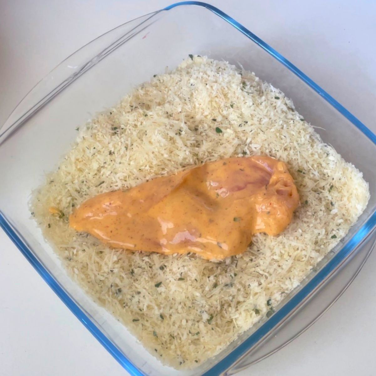 Coating the chicken cutlets with parmesan breadcrumbs.