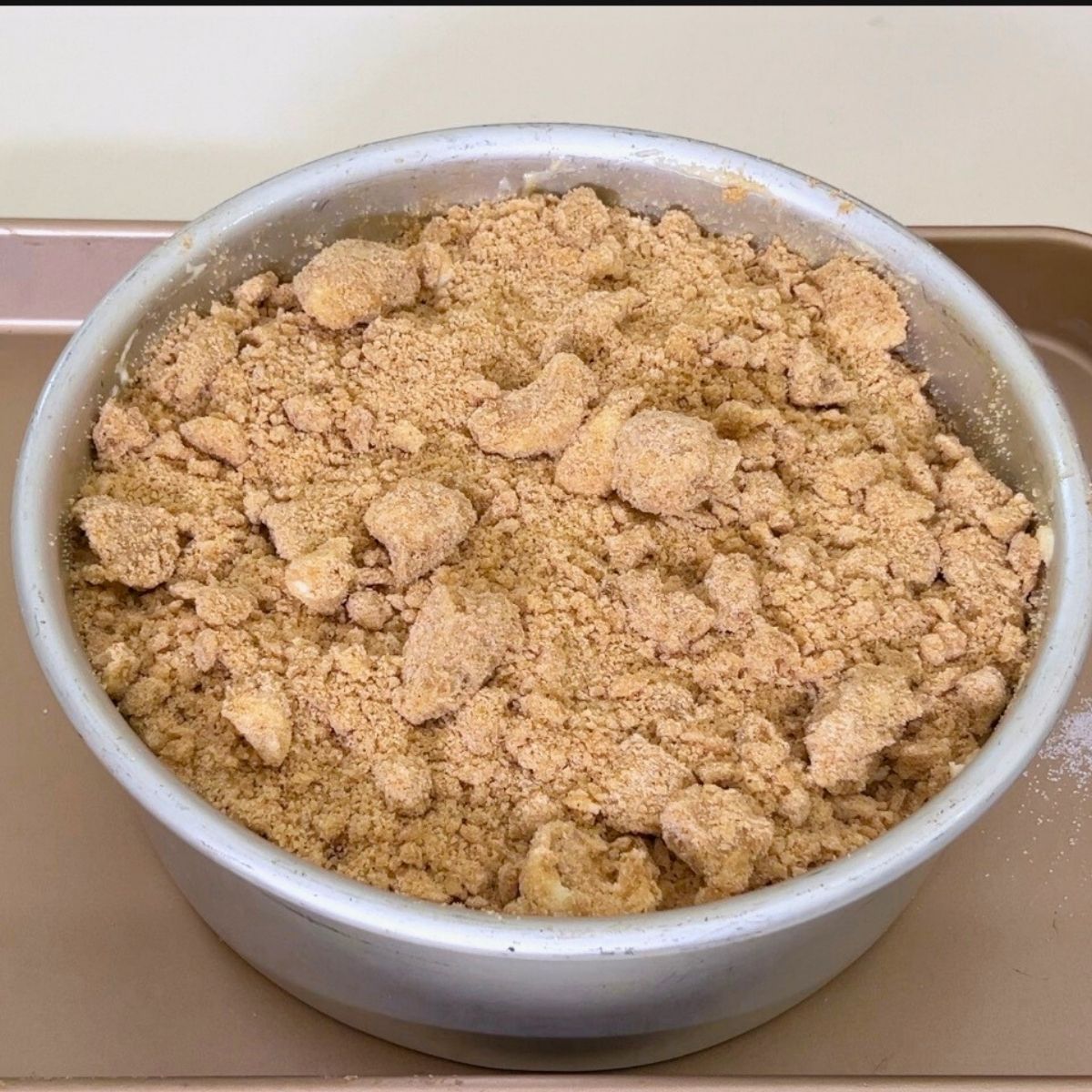 A cake pan with peach and crumb topping.