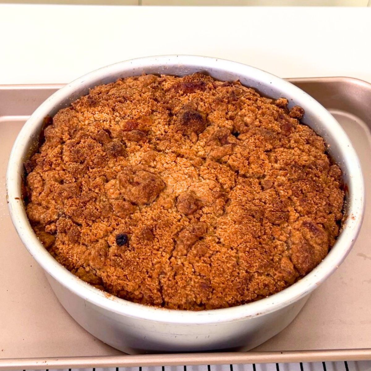 A cake pan with peach crumb cake freshly baked.