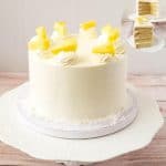 A Pina colada cake on a cake stand.