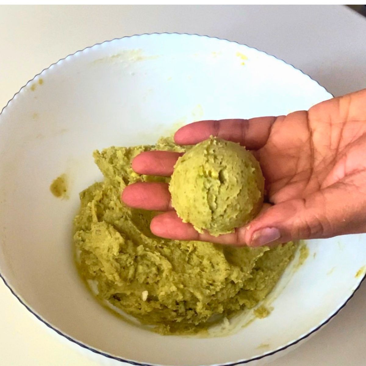 A ball of pistachio cookie dough for baking.