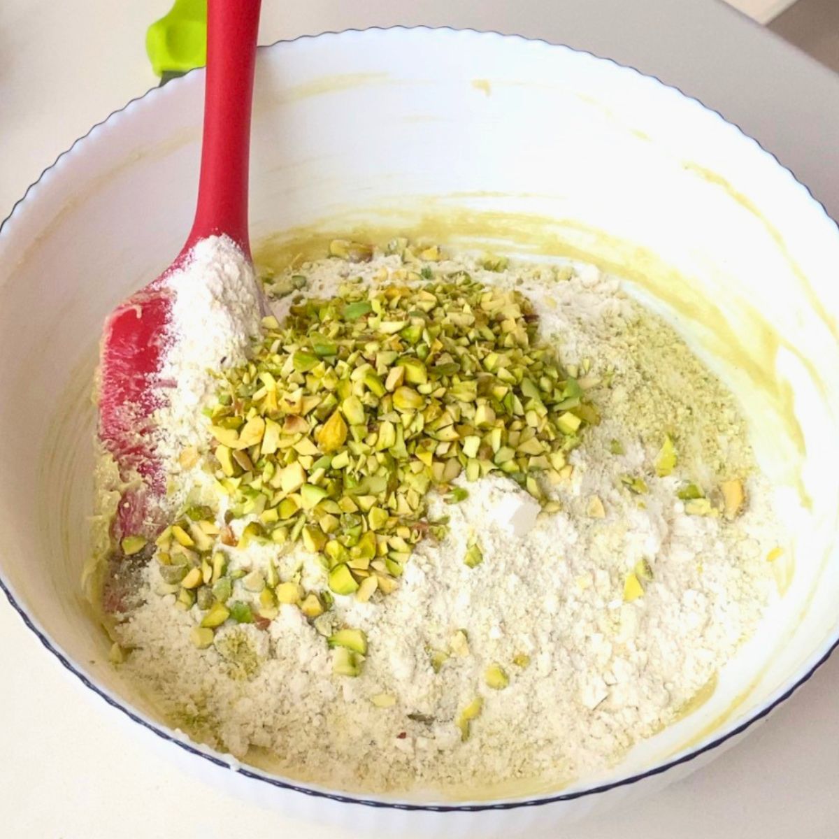 Add the flour and ground pistachios to the cookie dough.