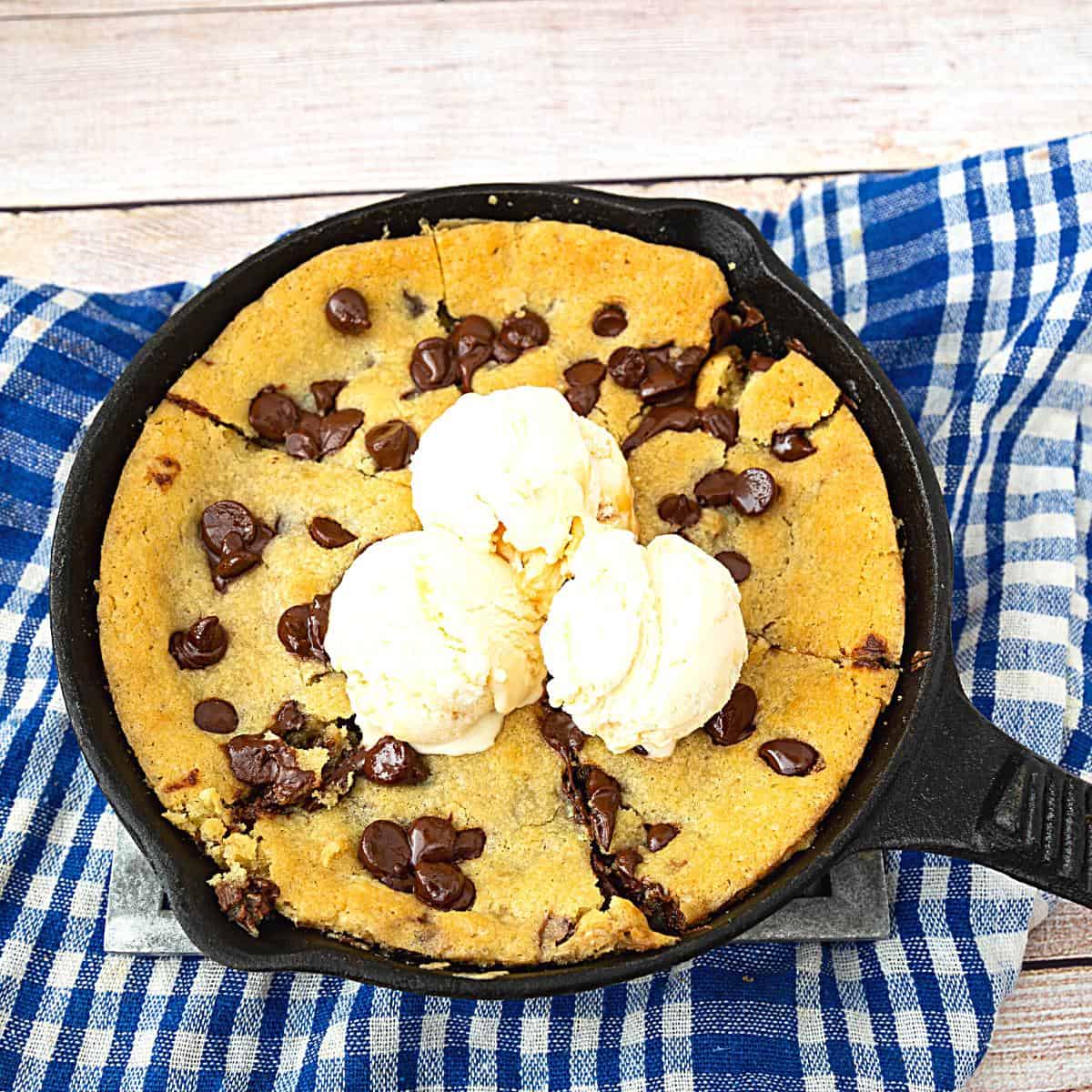 Chocolate chip cookie in a skillet with ice cream.