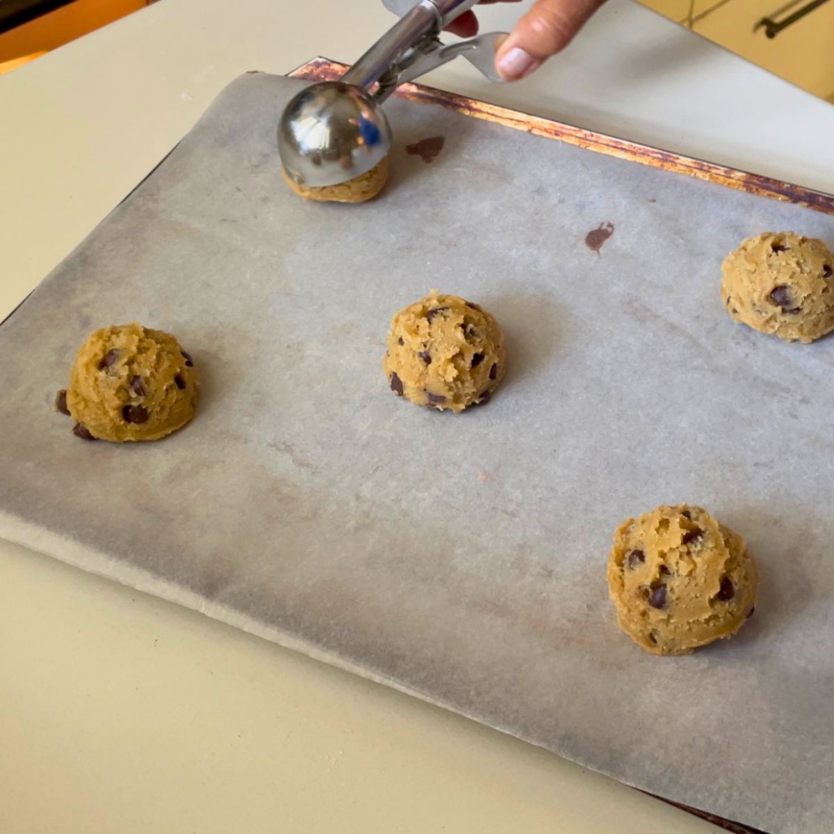 A sheet pan with chocolate chip cookie dough scoops.