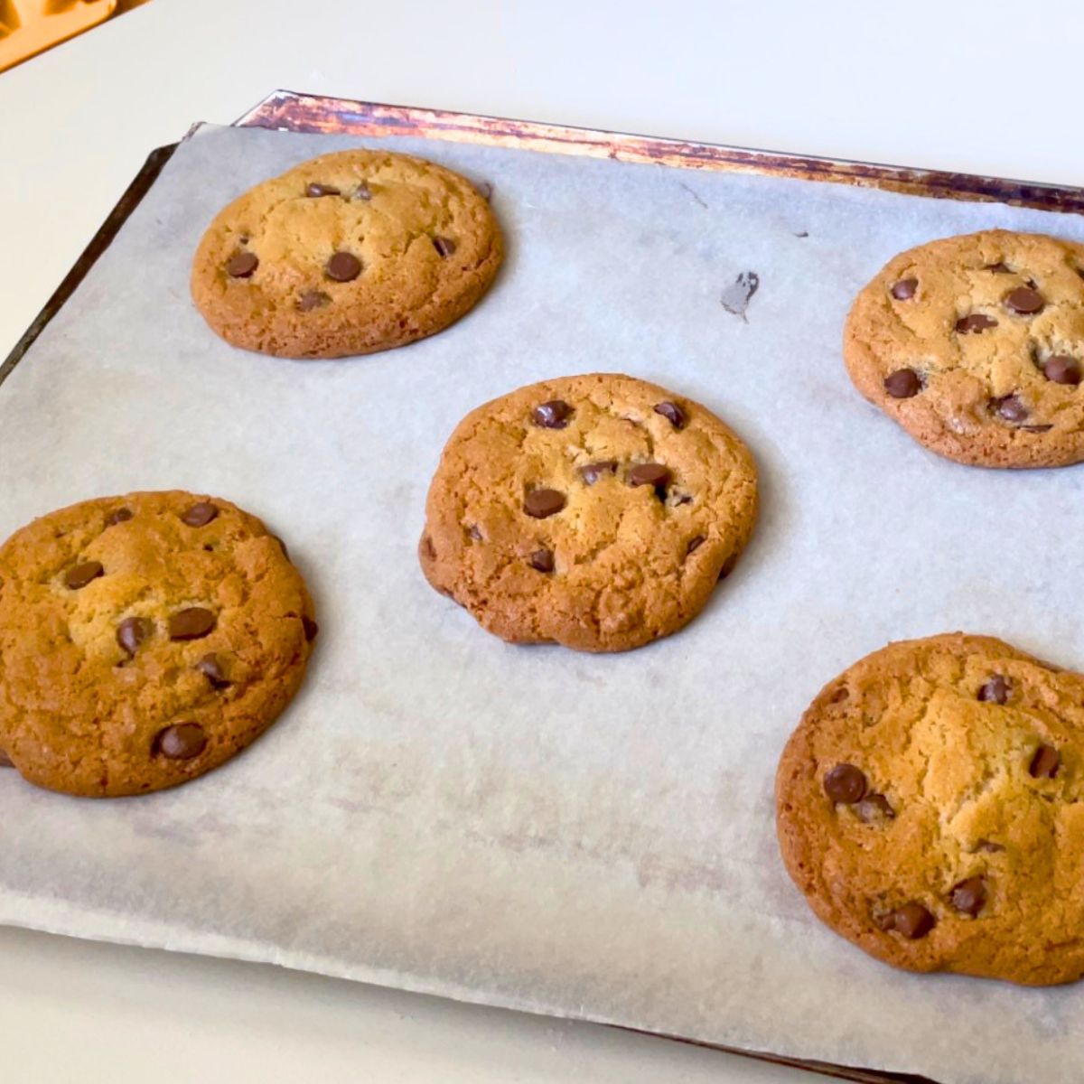 A baking tray with chocolate chip cookies.