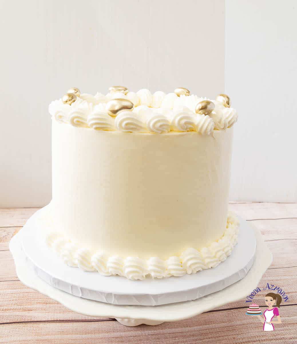 A white wedding cake on a cake board.