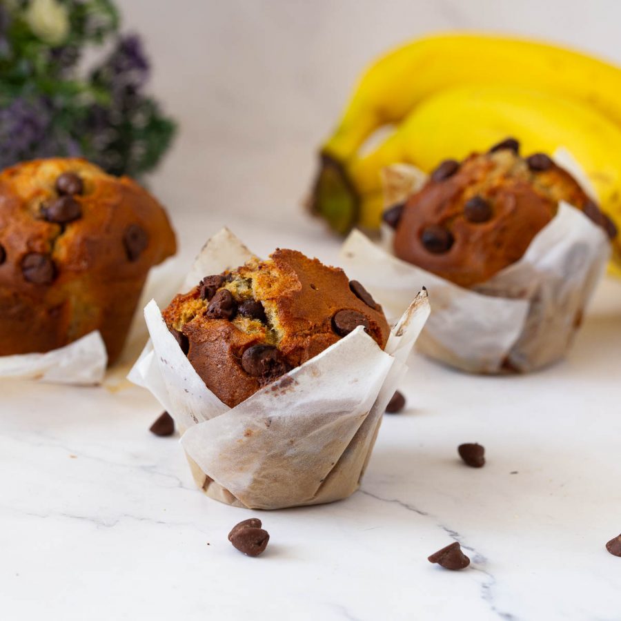 Bakery style domes muffins with banana and chocolate chips on the table.
