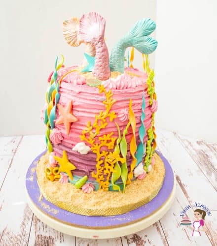 A mermaid birthday cake on a round cake board.