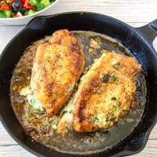 A skillet with chicken breast with Goat cheese.