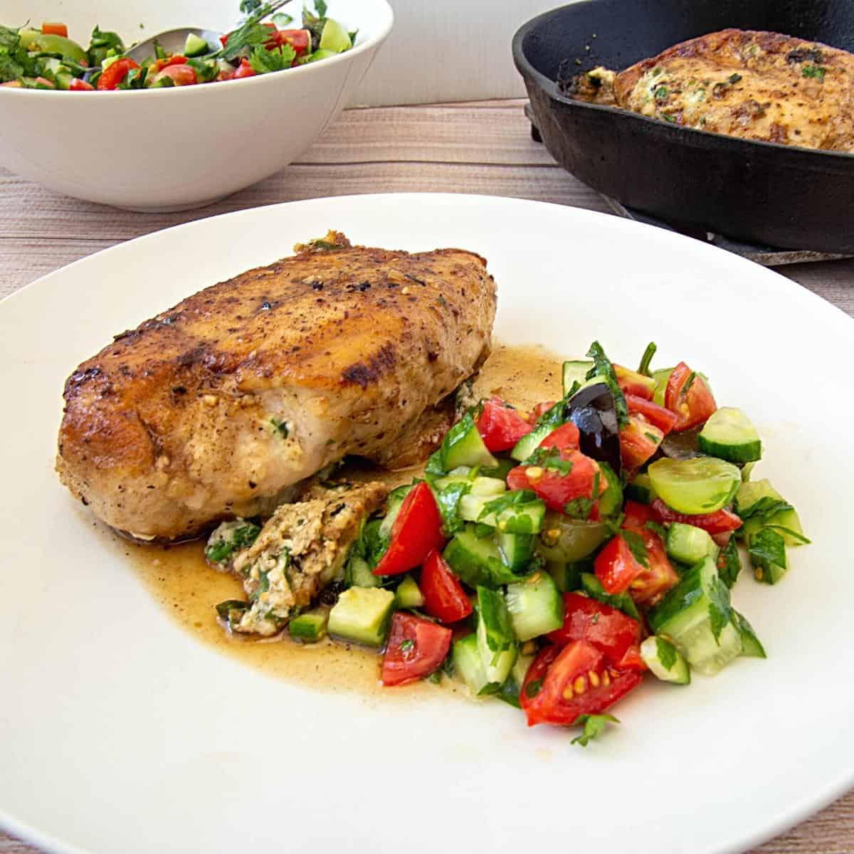 A plate with salad and stuffed chicken breast.