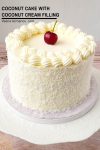 A coconut cake with a cherry on top.