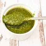 Pesto in a serving dish with a spoon.