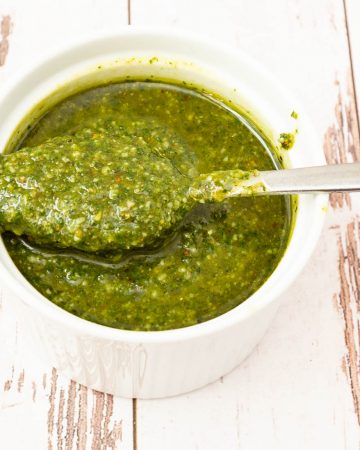 Pesto in a serving dish with a spoon.