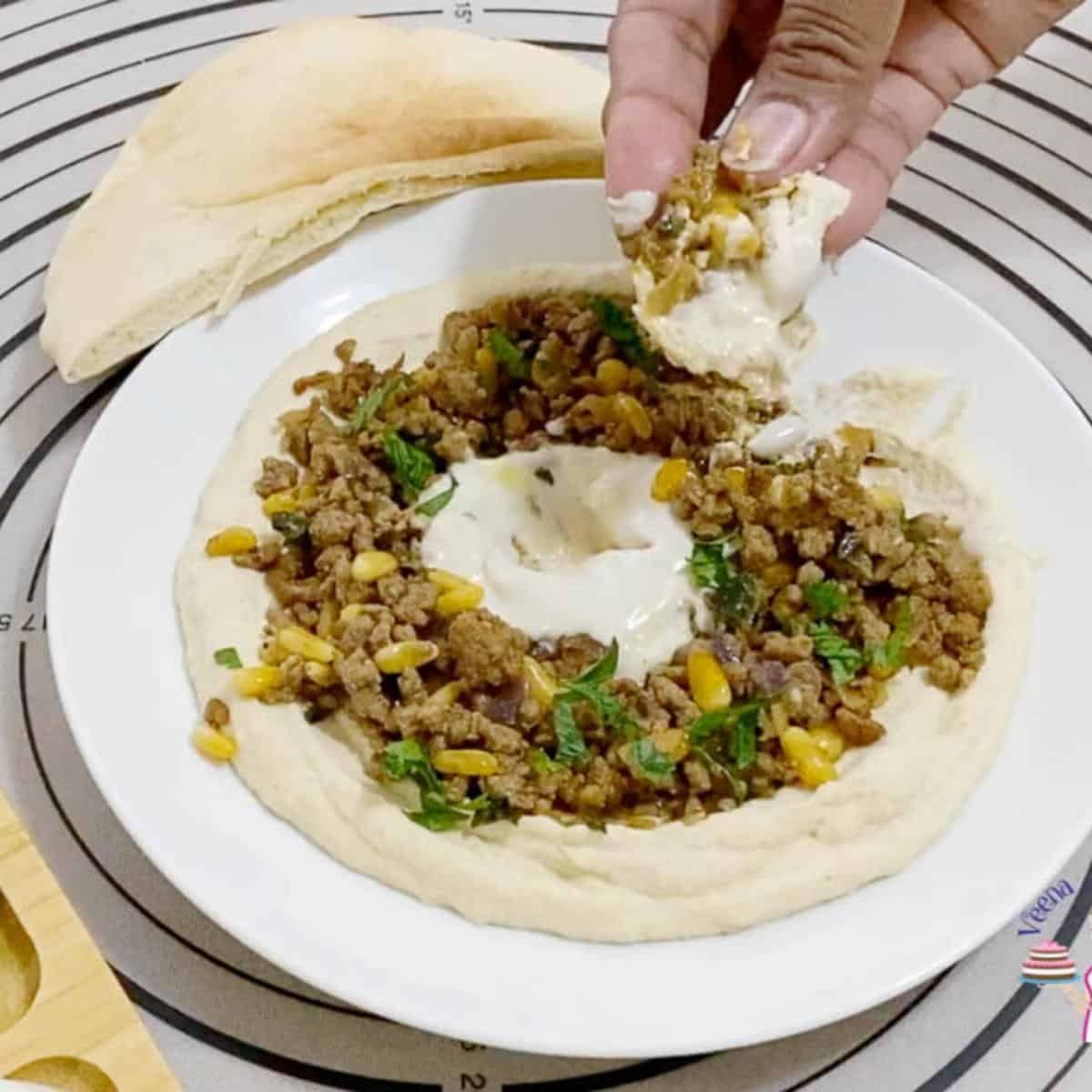 A plate with ground beef and hummus,