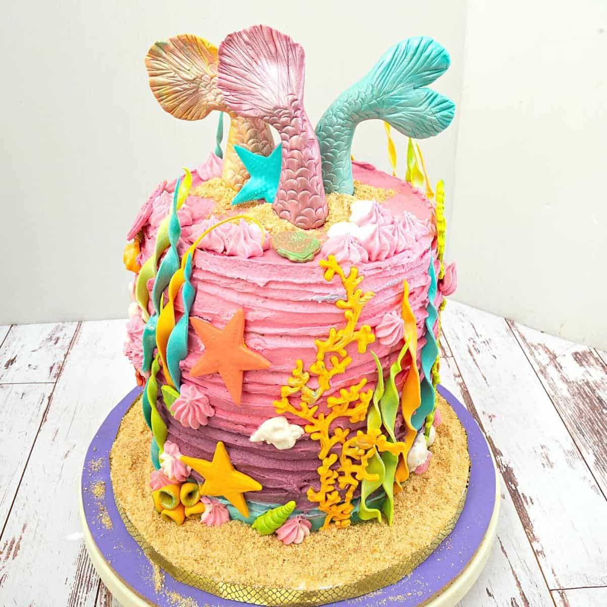 A buttercream cake frosted in mermaid colors.
