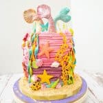 A mermaid birthday cake on a round cake board.