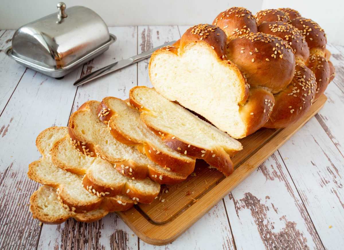 Sliced challah bread on a wooden board.