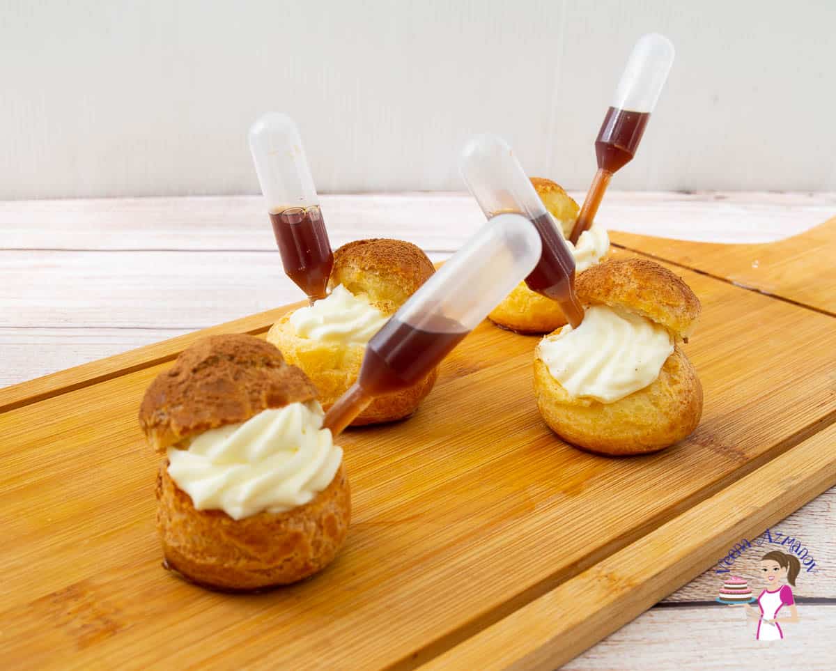 Tiramisu cream puffs on a wooden tray.
