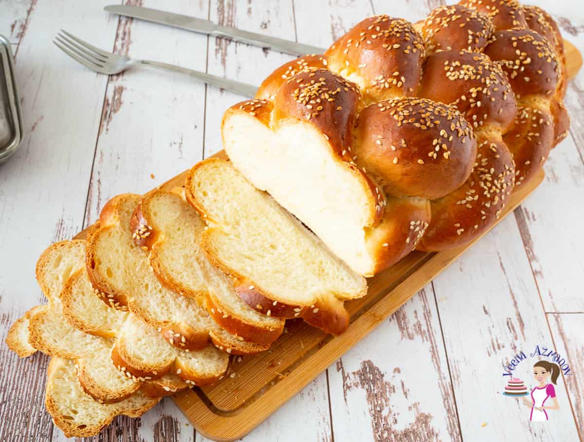 A sliced challah bread on a wooden board.