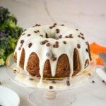 A glazed pumpkin bundt cake with chocolate chips.
