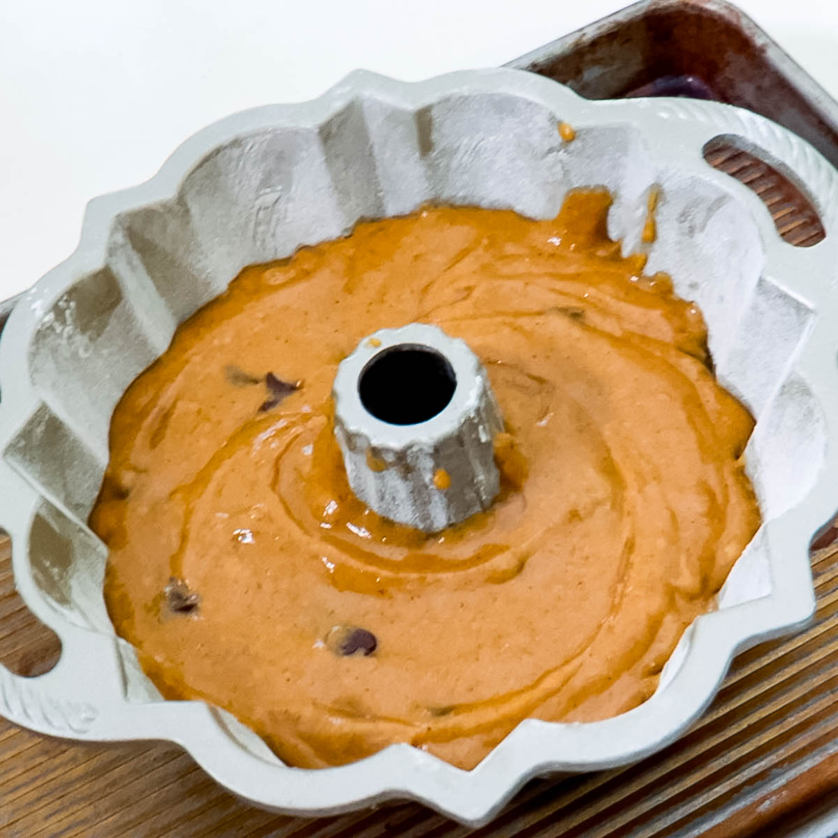 A bundt pan with pumpkin batter.