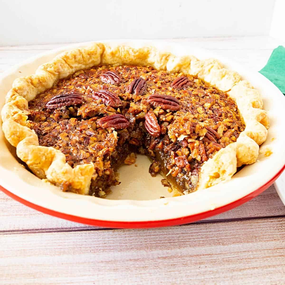Sliced pie with pecans in a pie pan.