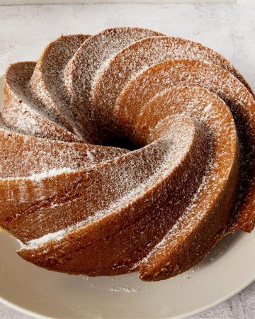 Sugar dusted bundt cake on a plate.