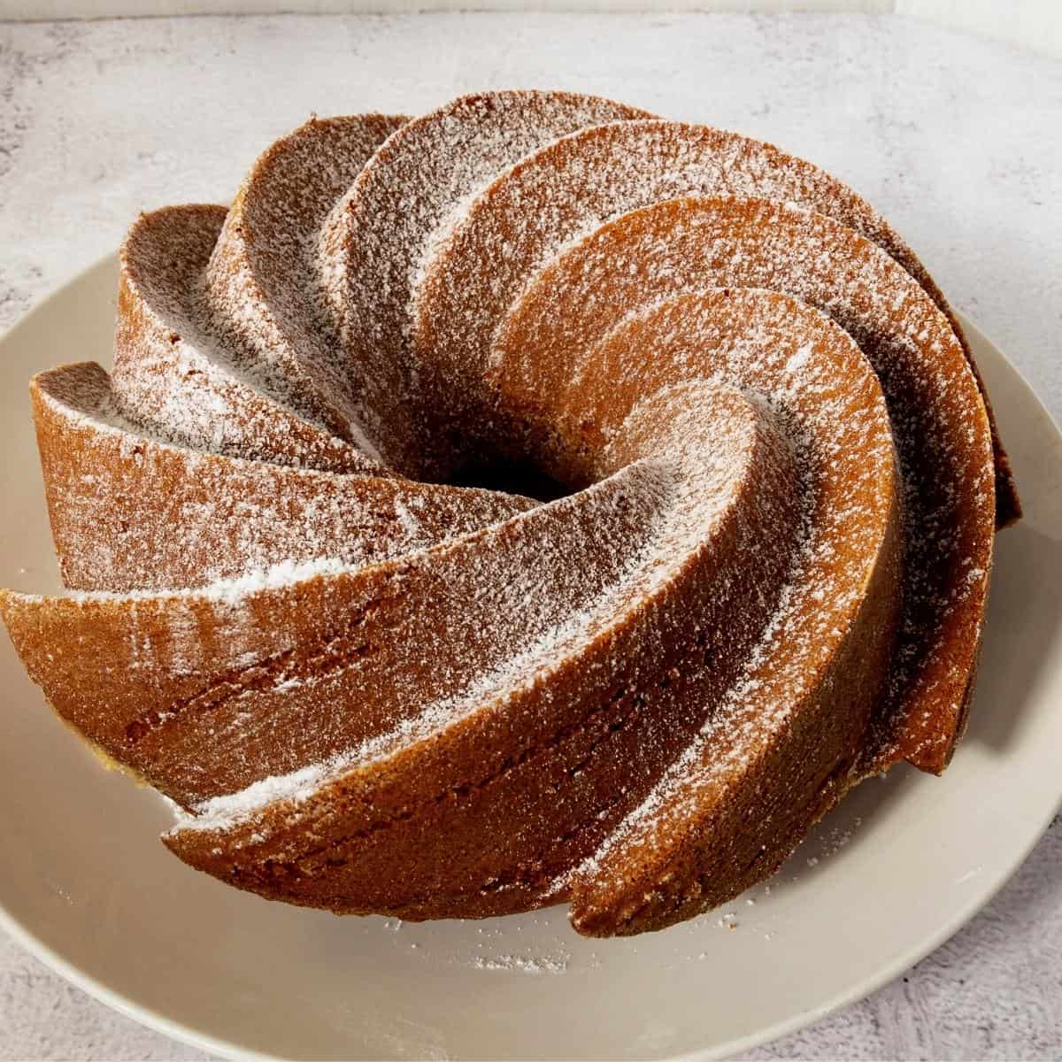 Sugar dusted bundt cake on a plate.