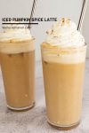 two glasses of cold pumpkin spice latte with foam.