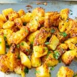 A baking tray with roast potatoes.
