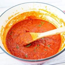A Dutch oven with tomato sauce.
