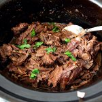 Slow cooker with shredded beef.