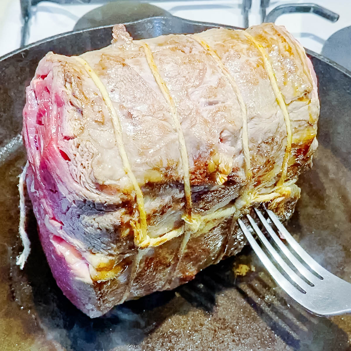 Searing the beef on a cast iron skillet.