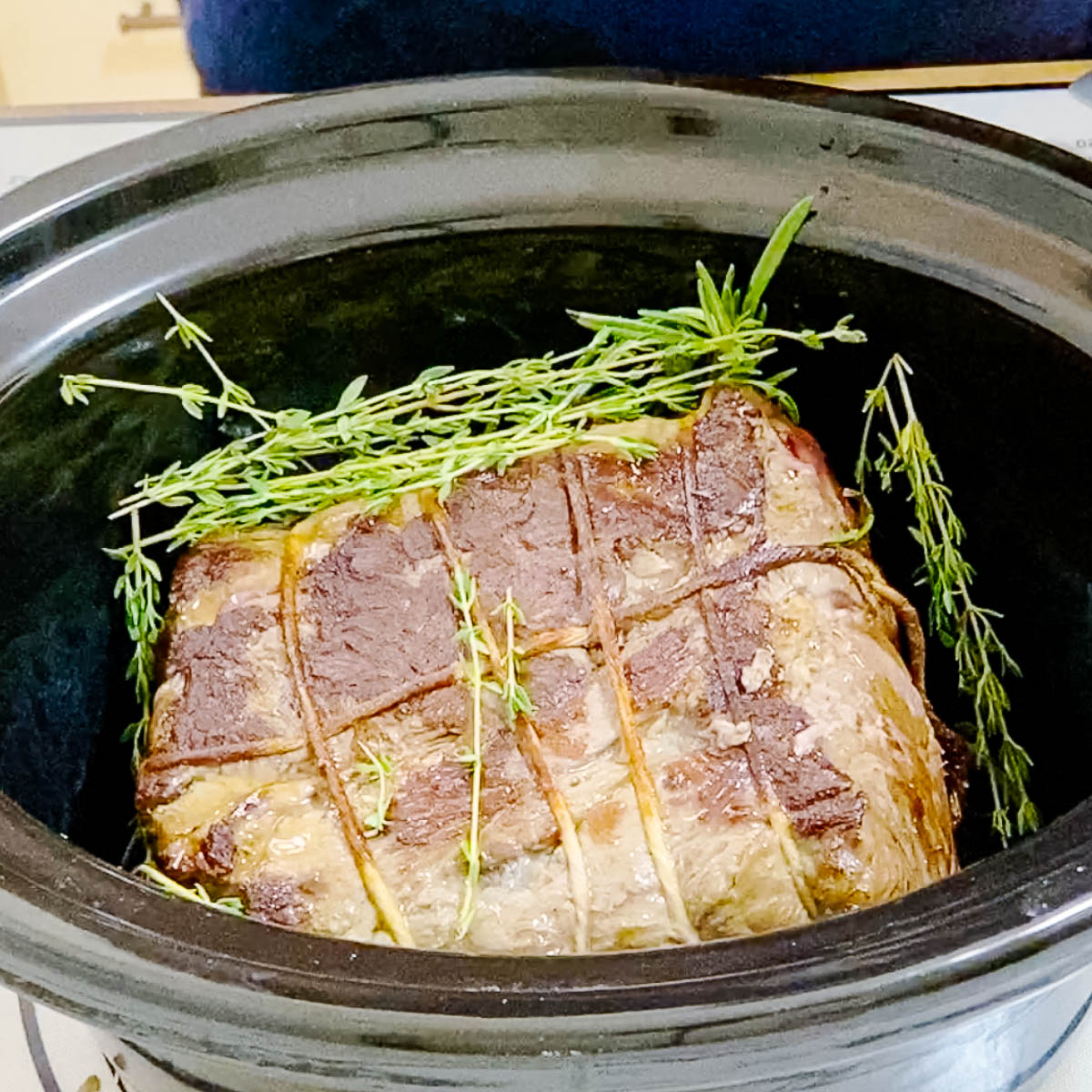 A slow cooker with shredded beef.