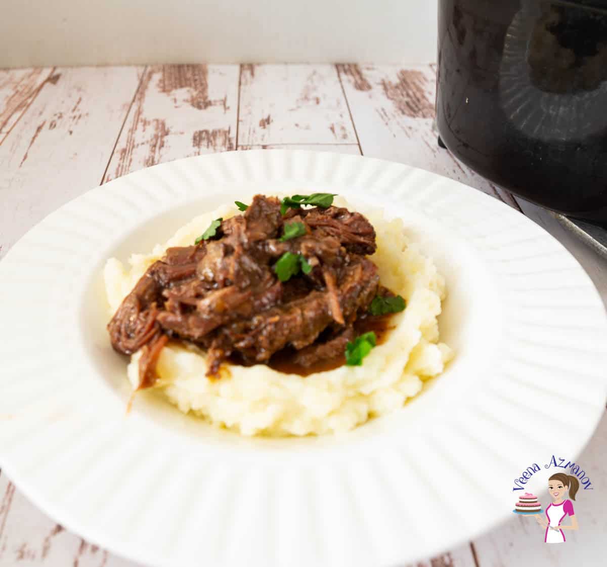 a plate with shredded beef and mashed potatoes 