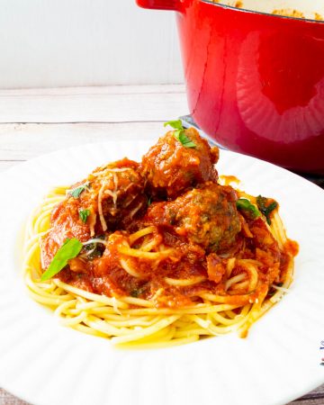 A plate of pasta bolognese with meatballs.