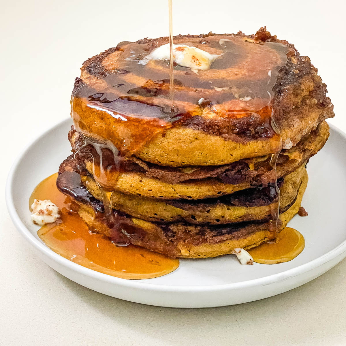 Cinnamon swirl pancakes stacked on a plte.