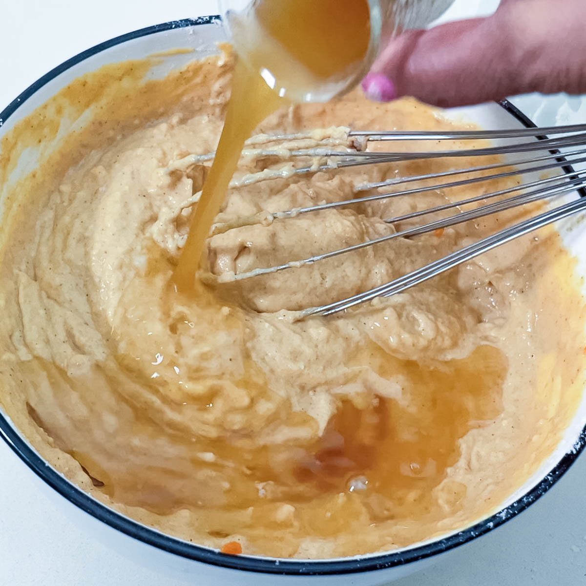 Adding brown butter to the pumpkin pancake batter.
