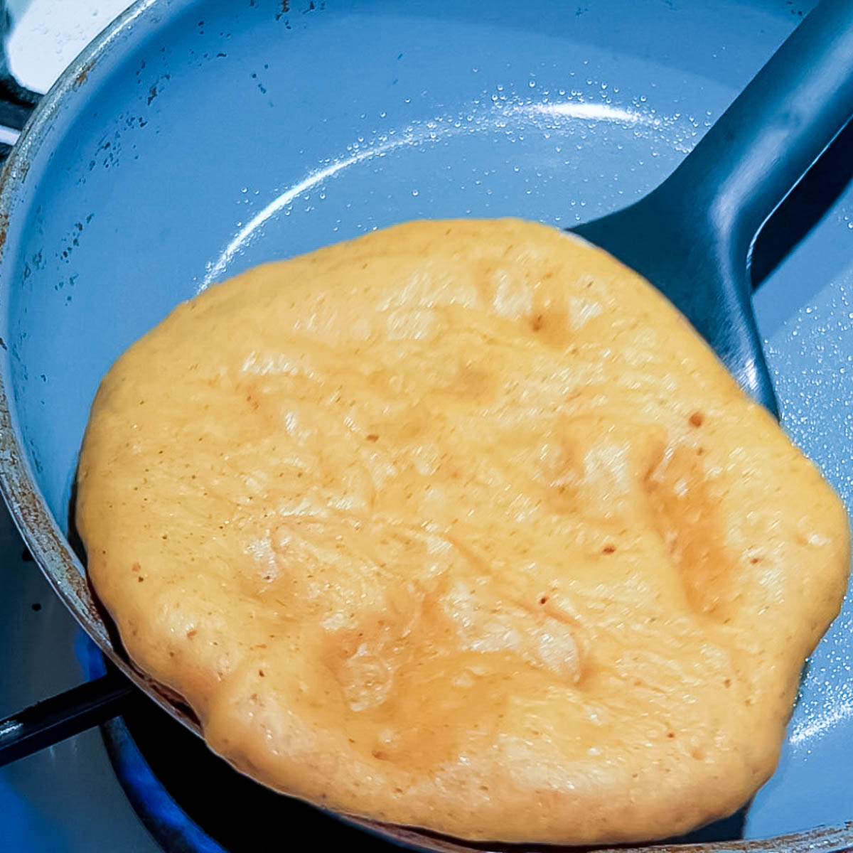 A frying pan with pancake to be flipped.
