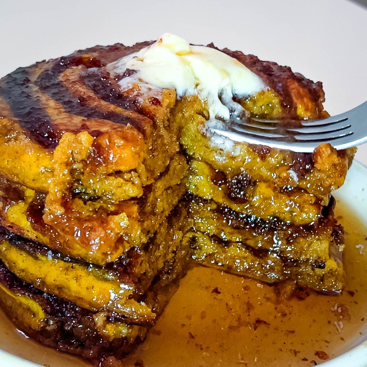 A stack of syrup soaked pancakes.