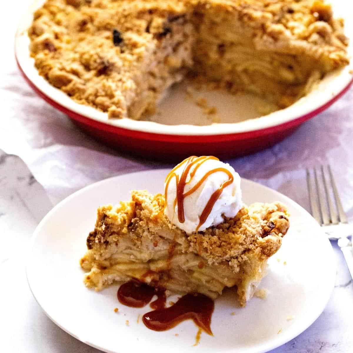 A slice of apple pie with crumbles.