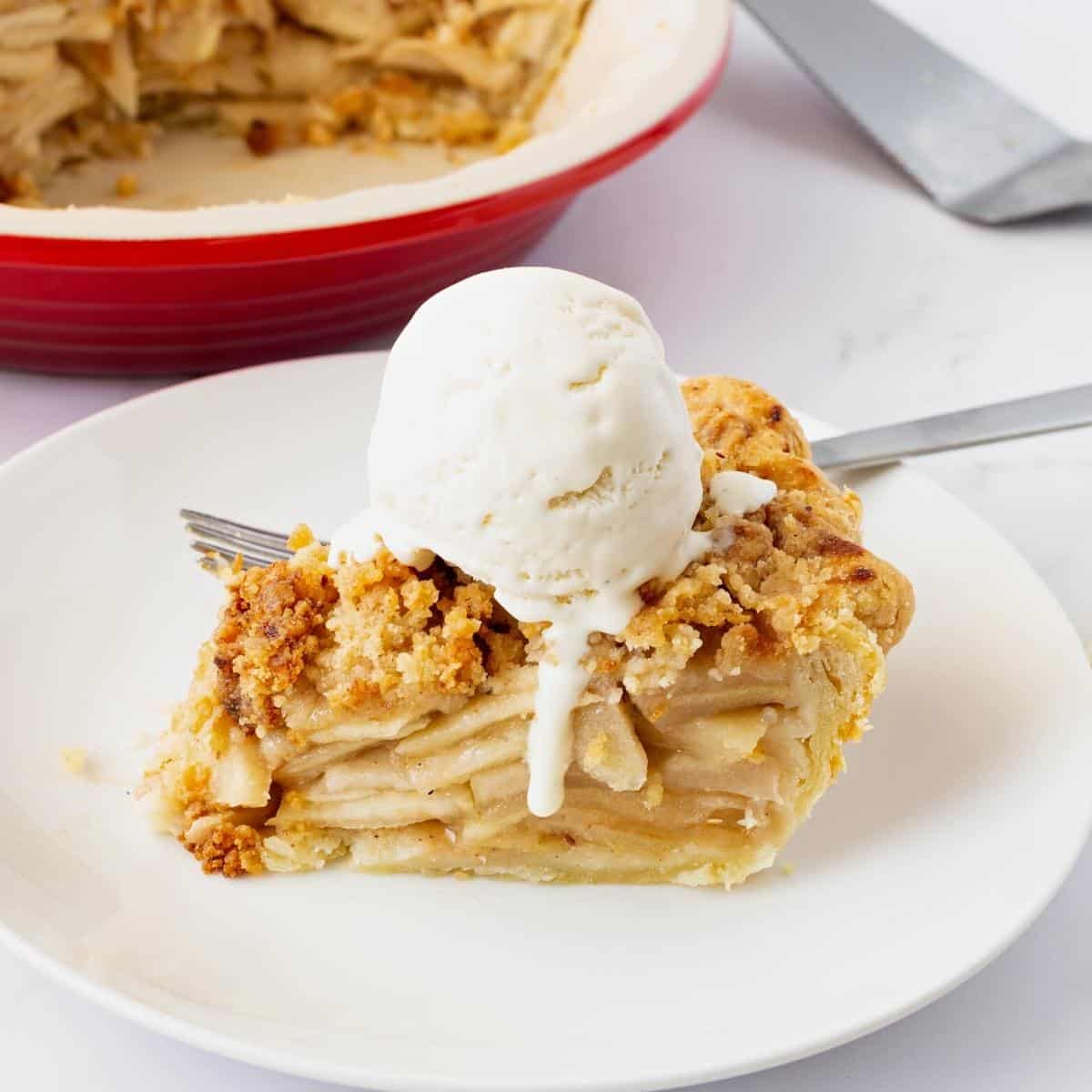 A slice of dutch apple pie with ice cream.