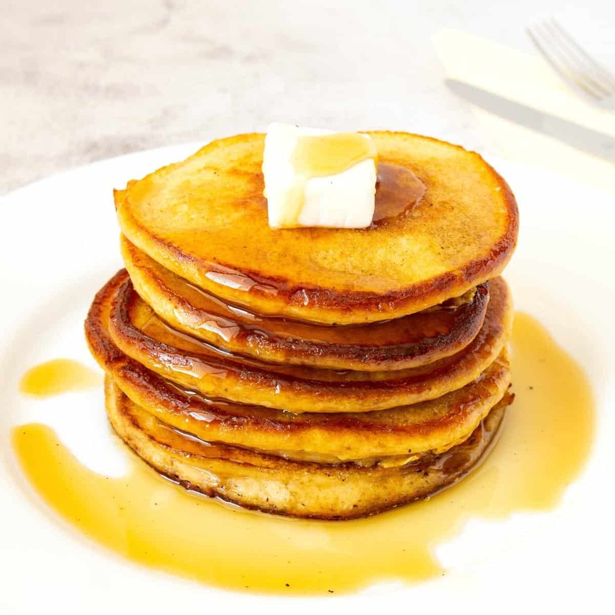 A stack of pancakes with butter.