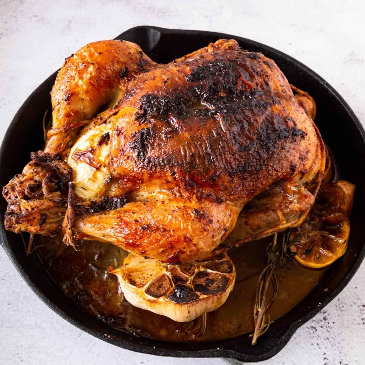 A skillet with roasted chicken.