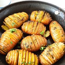 Hasselback potatoes in a skillet.